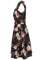Side view of 100% cotton dress with print featuring white blooms, tan foliage, and warm buttercup highlights on a black base.
