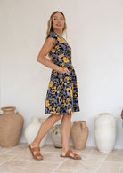Model wears a 100% cotton dress featuring cap sleeves, pockets and a generous A-line skirt.