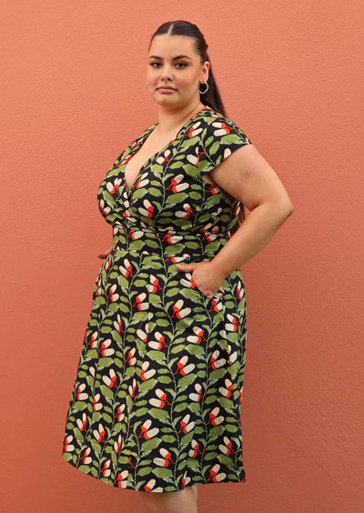 Plus size model wearing retro style Alice dress in black cotton with pockets