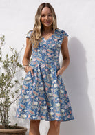 Model in retro style 100% cotton blue floral with cross over bodice and pockets, fit and flare style dress