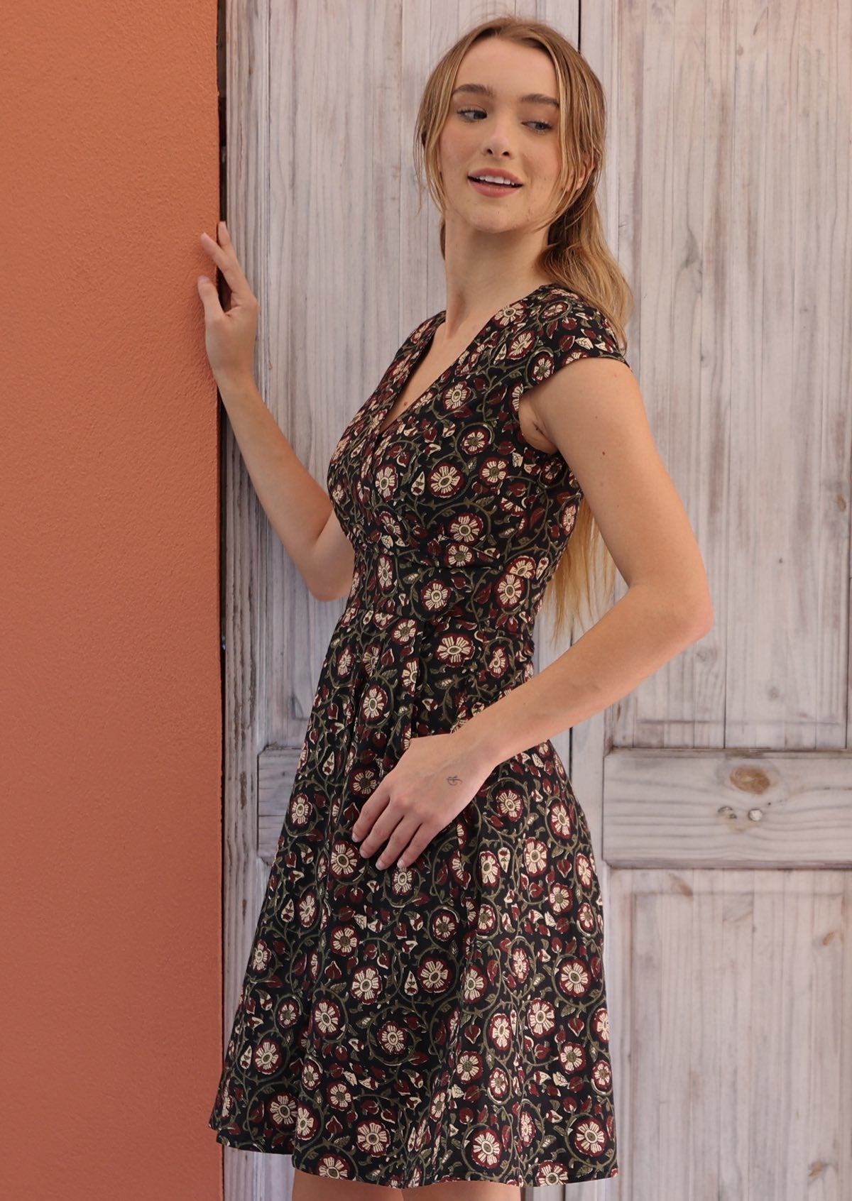 Woman posing in 100% cotton retro inspired dress with cross over bodice, cap sleeves and generous skirt
