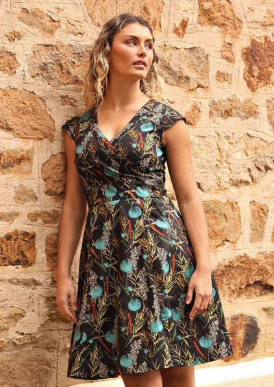 Model wears black base cotton retro dress with teal highlights