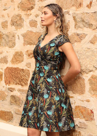 Model wears above knee retro dress with back zip