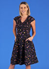 Woman wearing Alice Dress Astro black base 50's style dress with V-neck cross over bodice A-line skirt and pockets