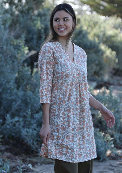 Model wears floral peach, green and cream tunic