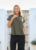 Woman wears 100% cotton shirt style relaxed fit olive green top with structured collar, short sleeves and V neckline