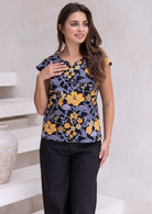 Model posing in a floral print tailored cotton top with cap sleeves, round neckline and length sitting at the hip 