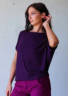 woman with dark hair wearing purple rayon batwing t-shirt