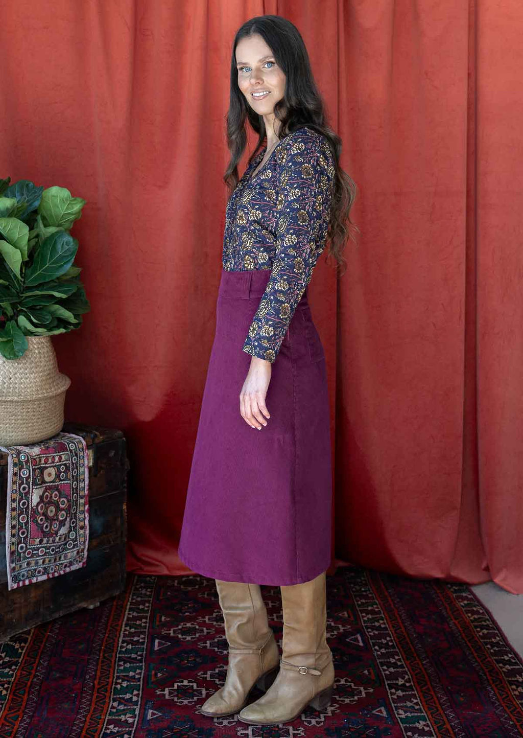 woman wearing purple corduroy skirt with cotton top and tan boots