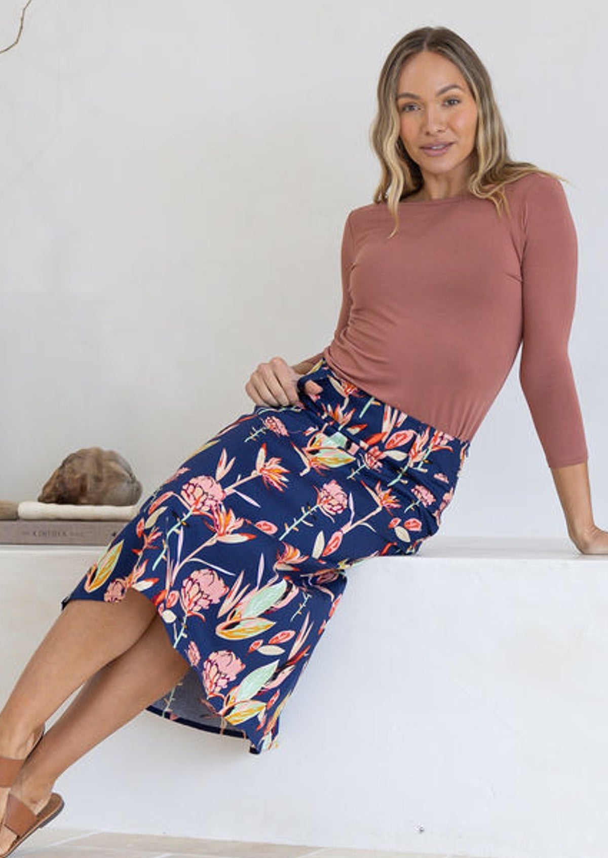 Woman in a sitting pose wears 100% cotton A line skirt with wide waistband.