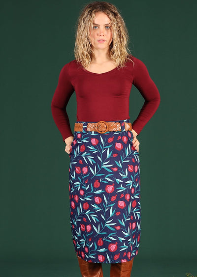 Woman wears shin length skirt with back pockets