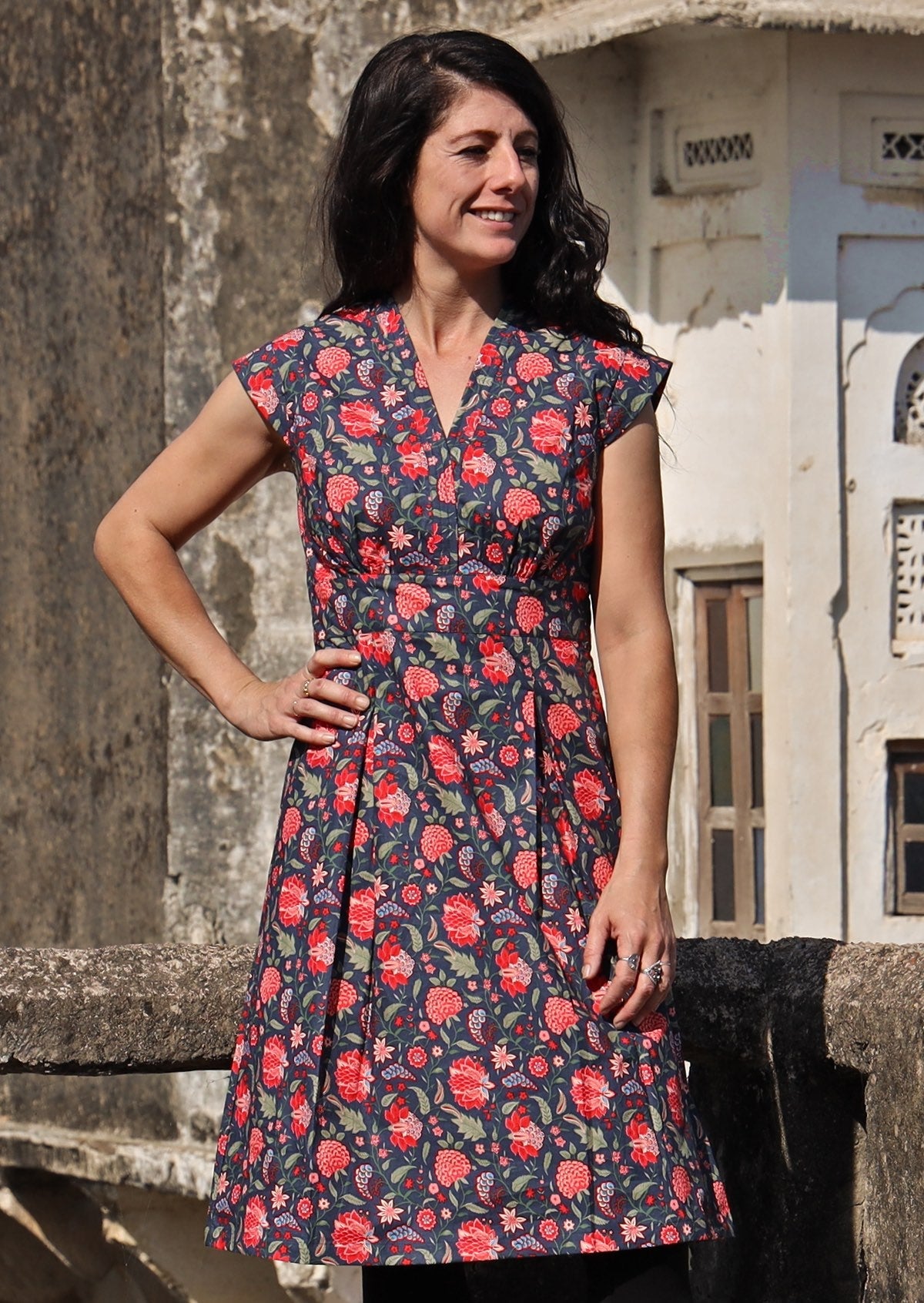 Model with hand on hip wearing navy blue based floral cotton retro style dress 