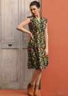 Model wears cotton dress with cap sleeves cinched waist with box pleats