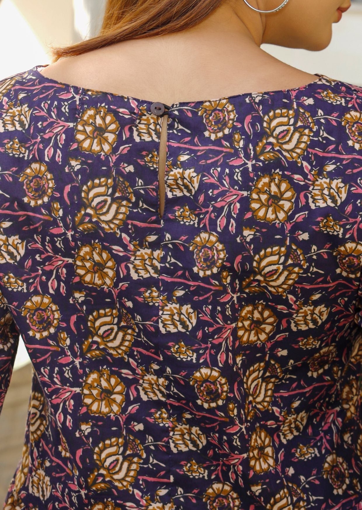 100% cotton floral print dress in dark purple with keyhole button closure at the back.