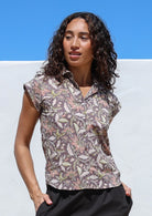 Woman wearing a slim fit button up shirt with shell buttons, structured collar and folded cuff sleeves