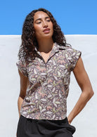 Model standing in sun wearing a 100% lightweight cotton button up shirt with folded cuff sleeves and collar