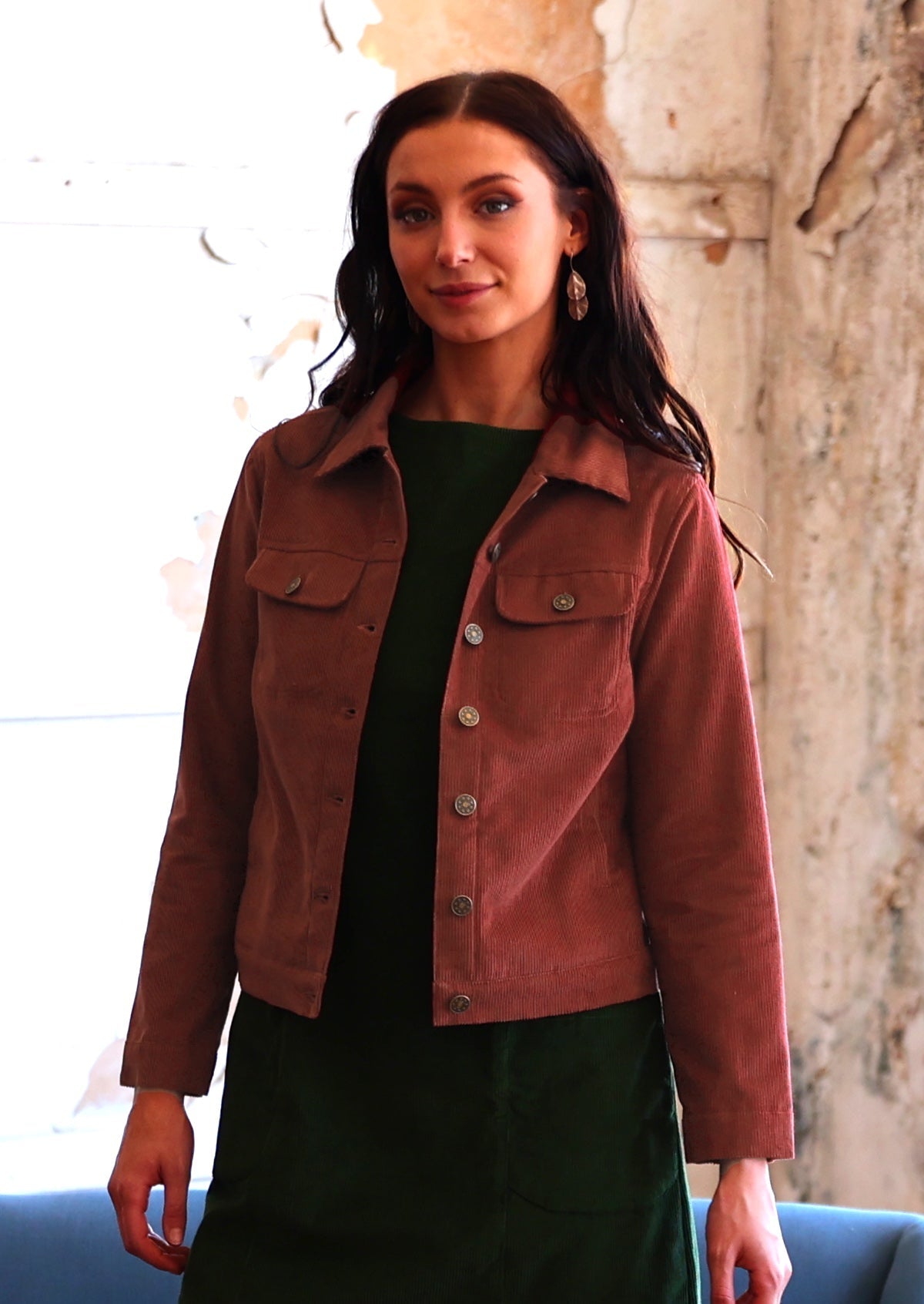 Woman in rust coloured cotton corduroy jacket over green corduroy tunic