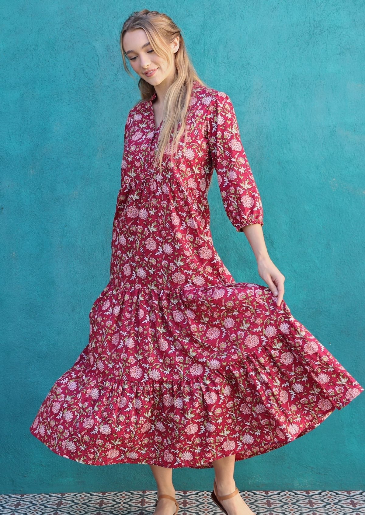 Woman spins in cotton maxi dress displaying voluminous tiered skirt, 3/4 sleeves and V-neckline