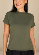 Woman wearing an olive green stretch rayonn t-shirt against a beige background