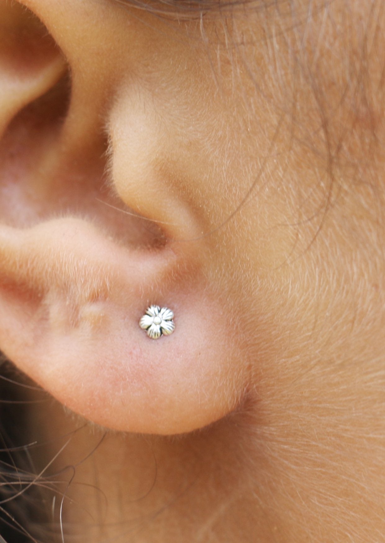 Delicate sterling silver dainty flower studs with soft, polished petals and bloom design 