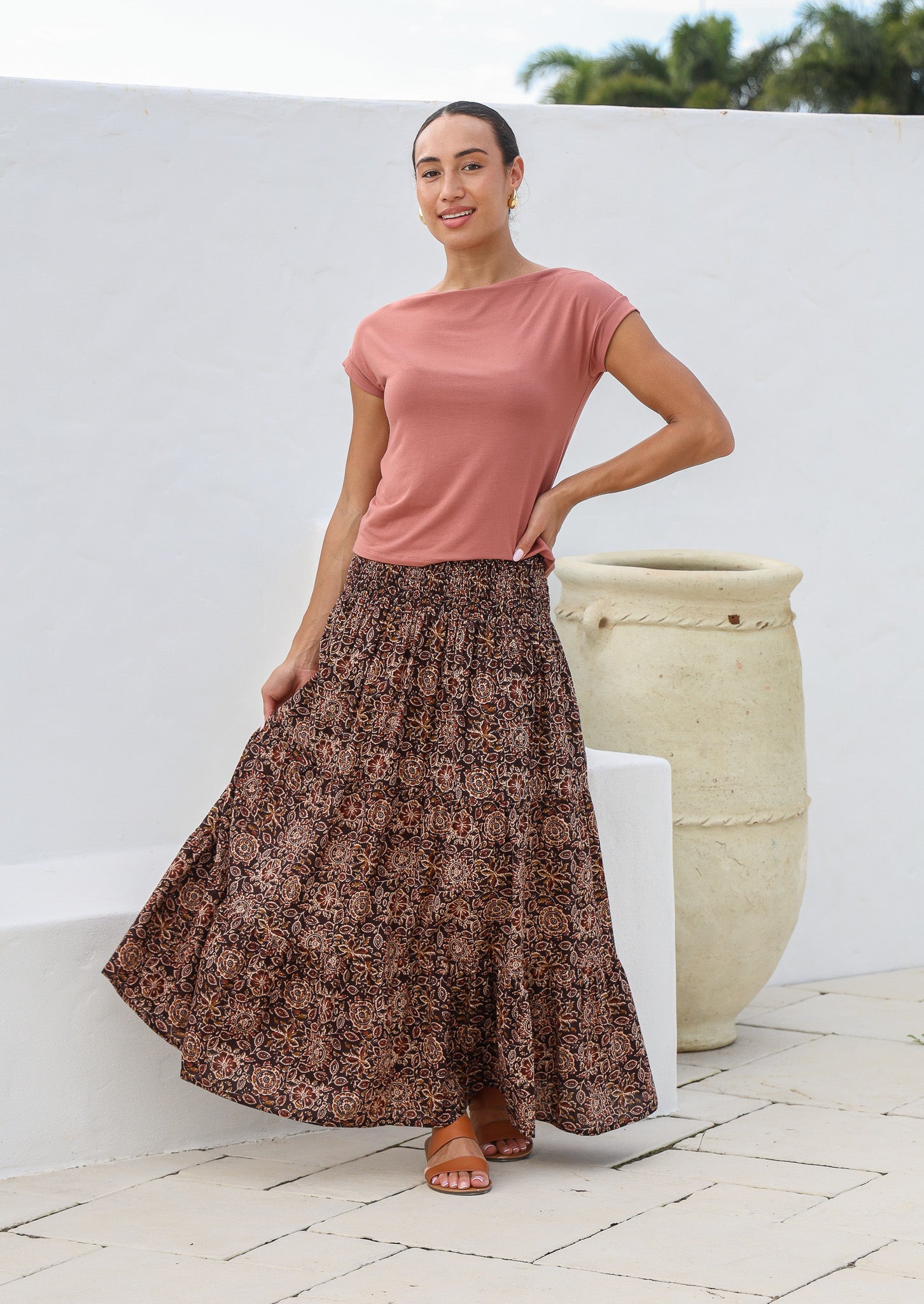 Model flaunting earthy brown floral print cotton maxi skirt with a wide shirred elastic waistband.