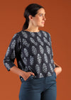 Woman with dark hair in navy blue boxy style cotton blouse with 3/4 sleeves