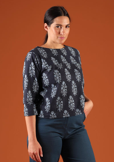 Woman with dark hair in navy blue boxy style blouse