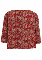 Back view of red based floral top features round neckline and 3/4 sleeves with buttons down the back.