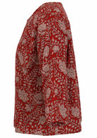 Side view of red based floral top with round neckline and 3/4 sleeves