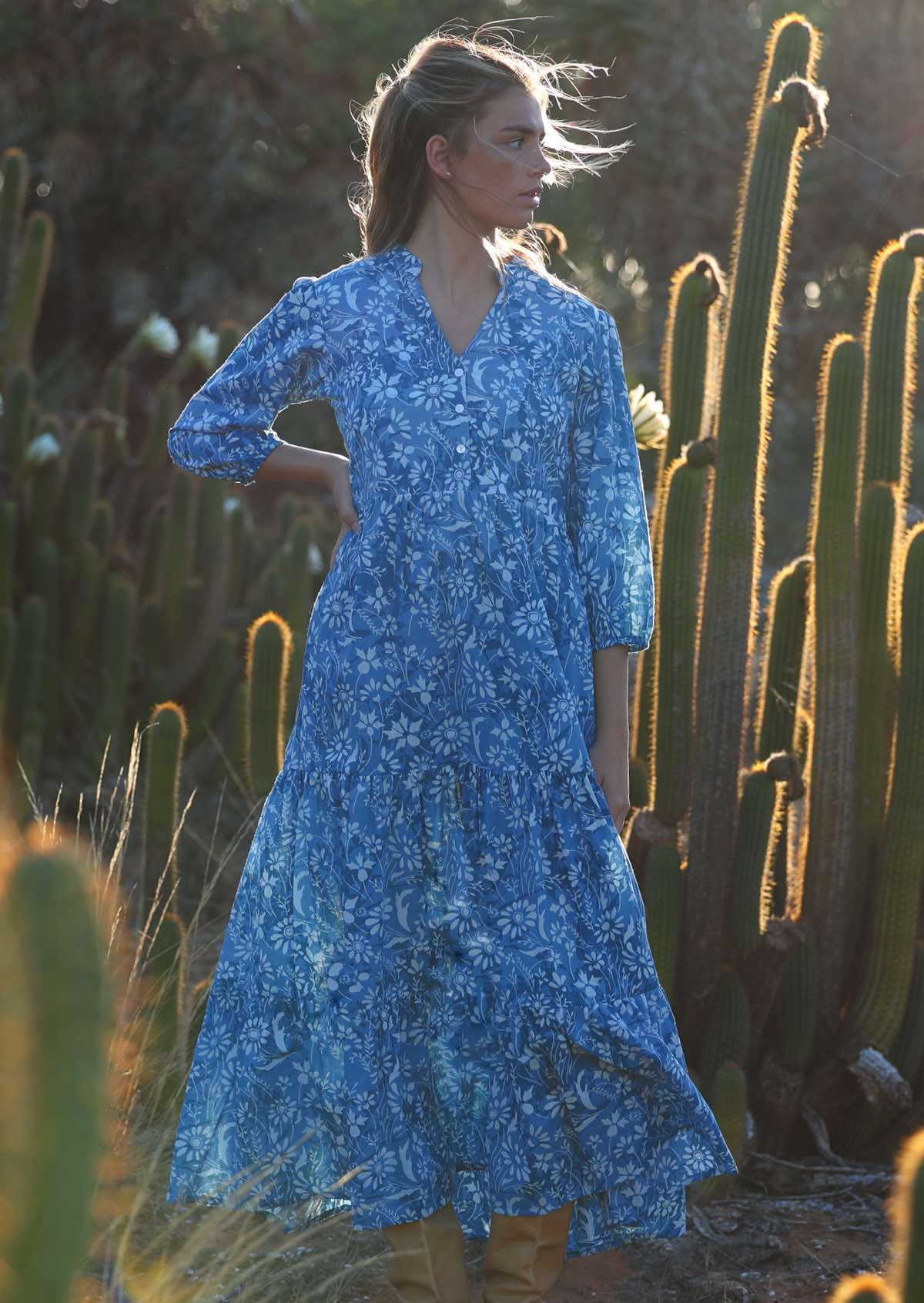 woman in blue cotton maxi dress with light blue and white floral print with hand on hip