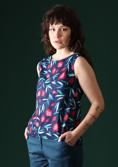 Model wears fruit print pattern top with a navy base.