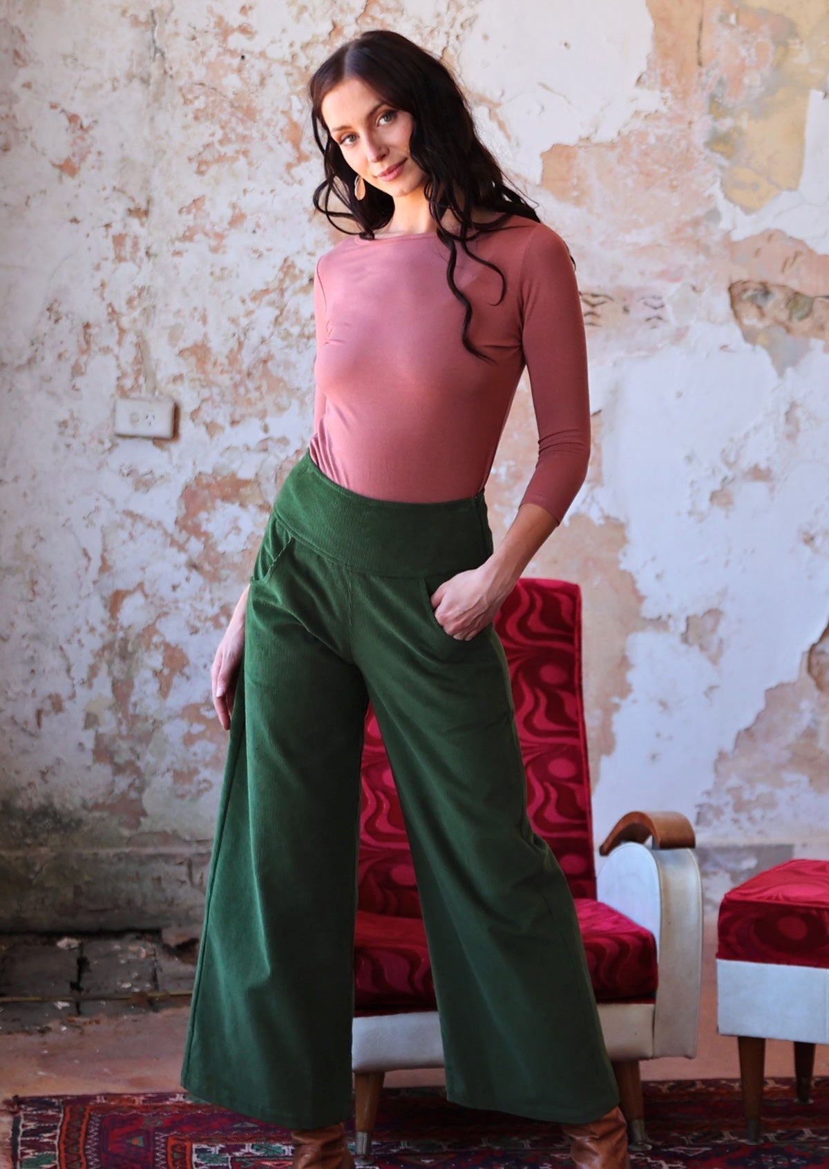 olive green wide leg corduroy pants with wide waistband, side zip and pockets with hand in pocket 