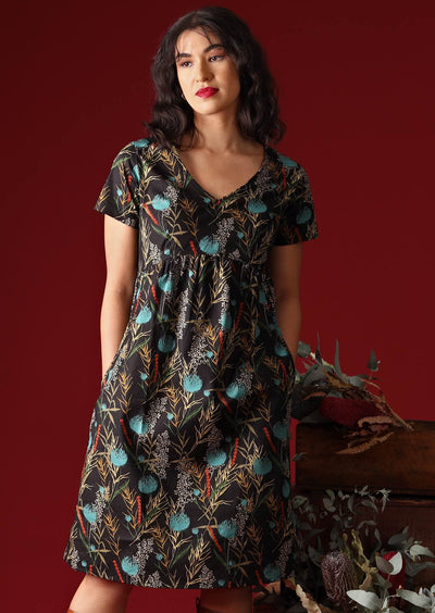 Model wears black base botanical print cotton dress with pockets