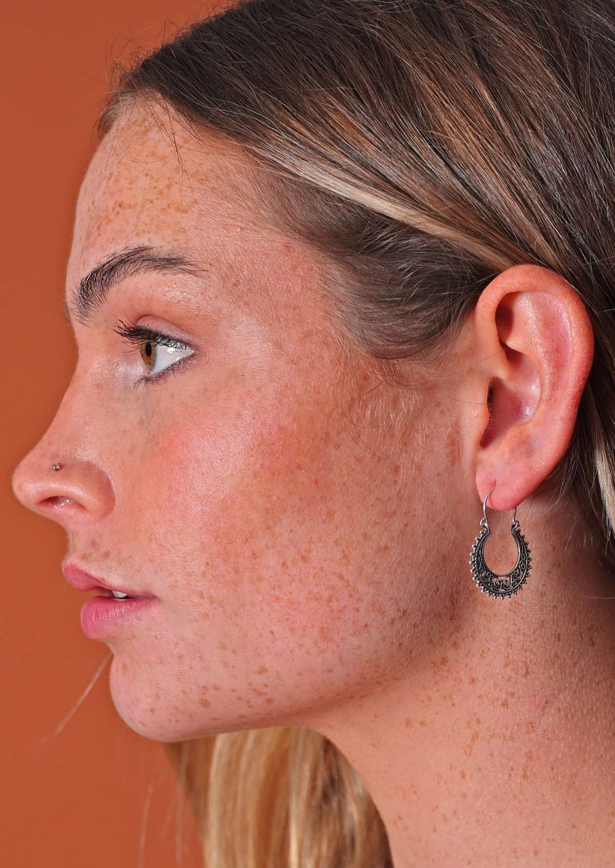 Model wears detailed lacy sterling silver wire hook earrings