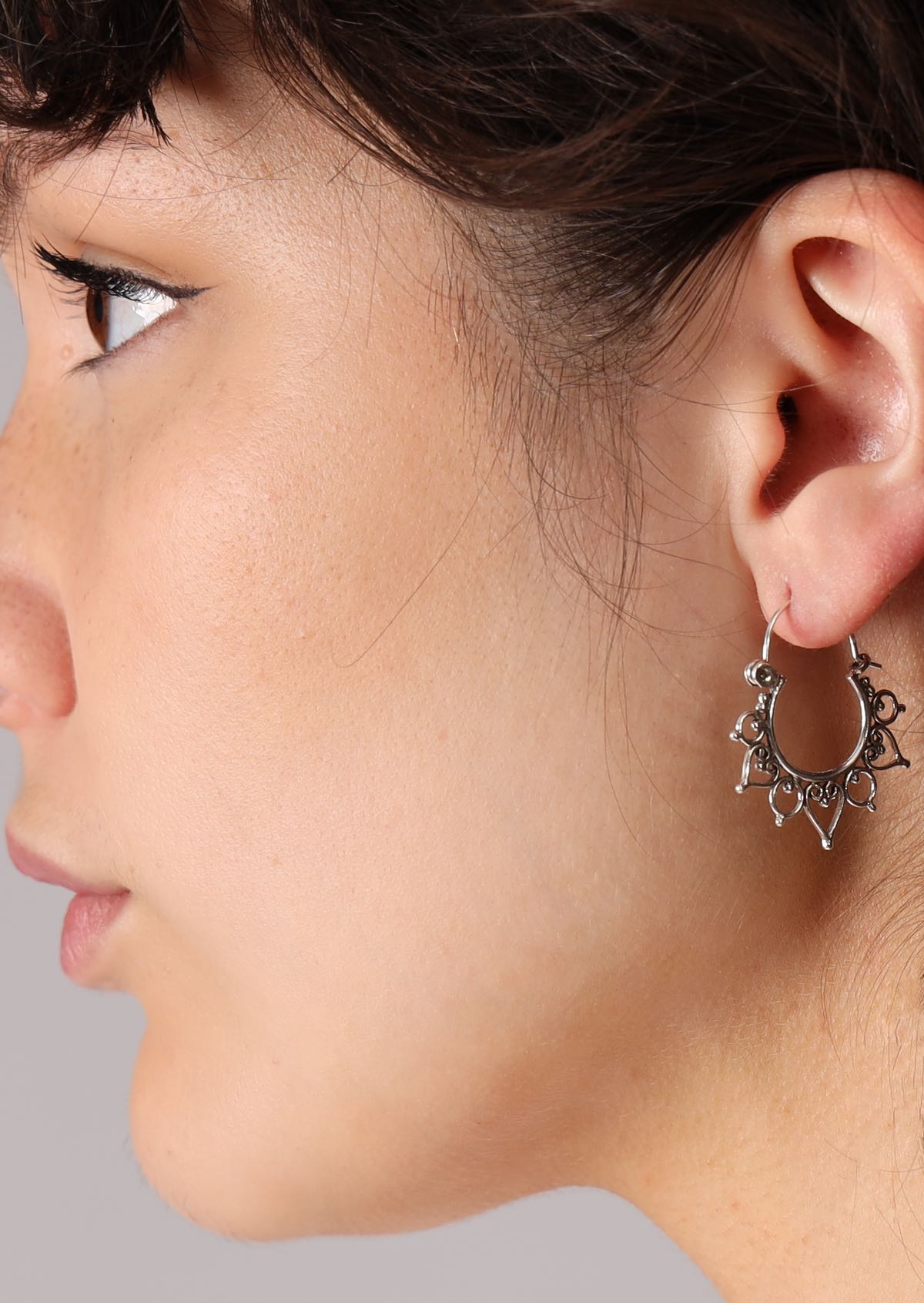 Sterling silver boho hoops with hearts and circles adorning the outer edge