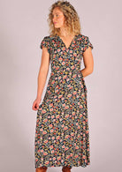 Model standing holding one side of skirting of navy floral rayon wrap maxi sundress 
