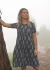 Woman standing on misty mountain top wearing navy blue cotton Indian print dress