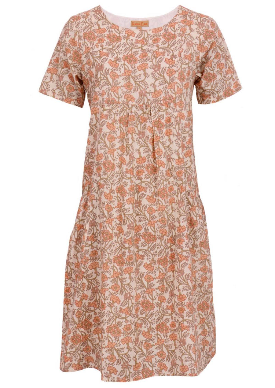 Model wears a 100% lightweight cotton knee length dress with pockets. The floral pattern of peach and olive green is on a cream base. This short sleeve dress is loose fit and lined.