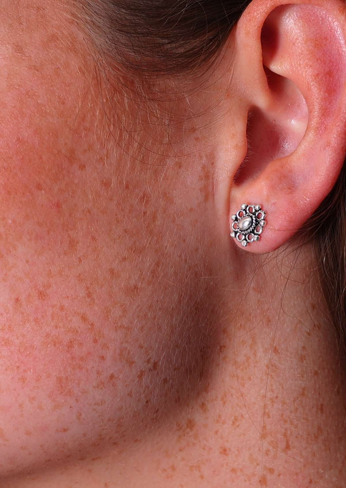 Sterling silver ornamental design stud earrings with circles surrounding central oval shape