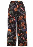 Back view of 100% cotton wide leg pants with elastic waist and pockets in black based botanical print