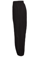Side view of wide leg black cotton pants with elastic waist, pockets and pleated ankles 