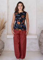 Woman wears burnt henna wide leg cotton pants with pockets and pleats at the ankles