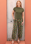 Model wears Greta Pants Oak green orange and white speckled botanical print cotton wide leg pants that taper to the ankles with pockets | Karma East Australia