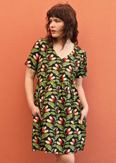 Model wears Harlow Dress Oak cotton V-neck loose fitting above knee dress with hidden side pockets