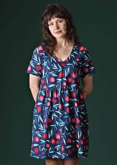 Model wears loose fitting dress with pockets.