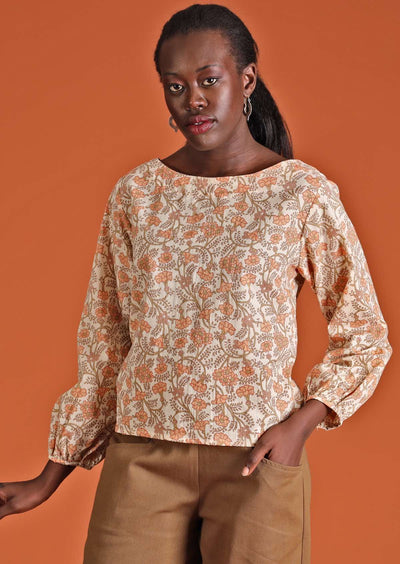 Model in cotton floral women's top, cream with apricot coloured flowers