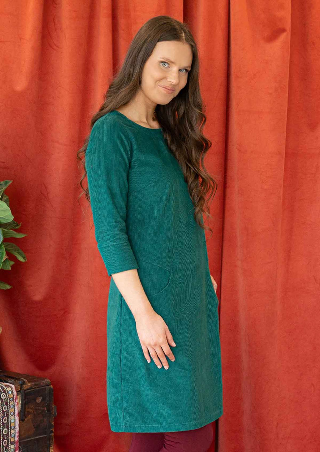 Woman wearing teal corduroy dress over leggings