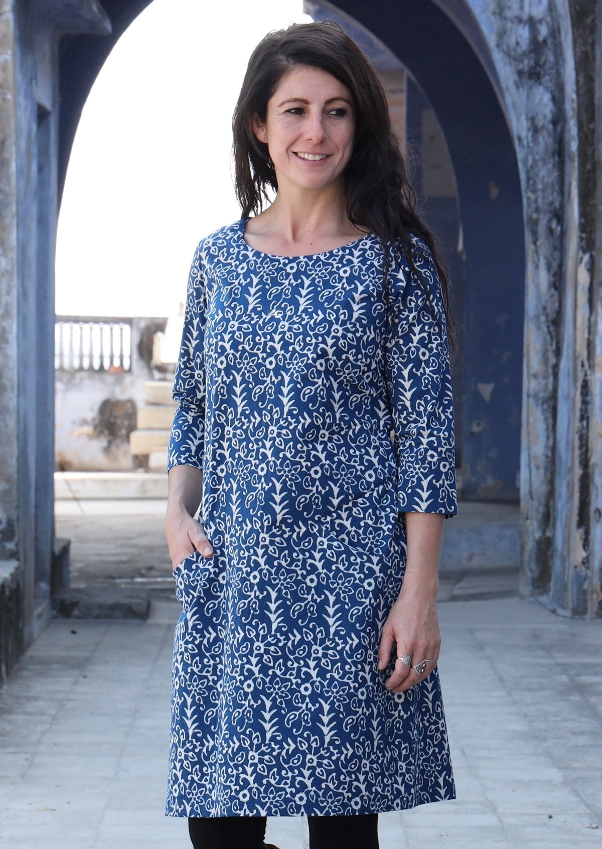 Woman standing with one hand in pocket wearing 100% cotton blue and white dress 