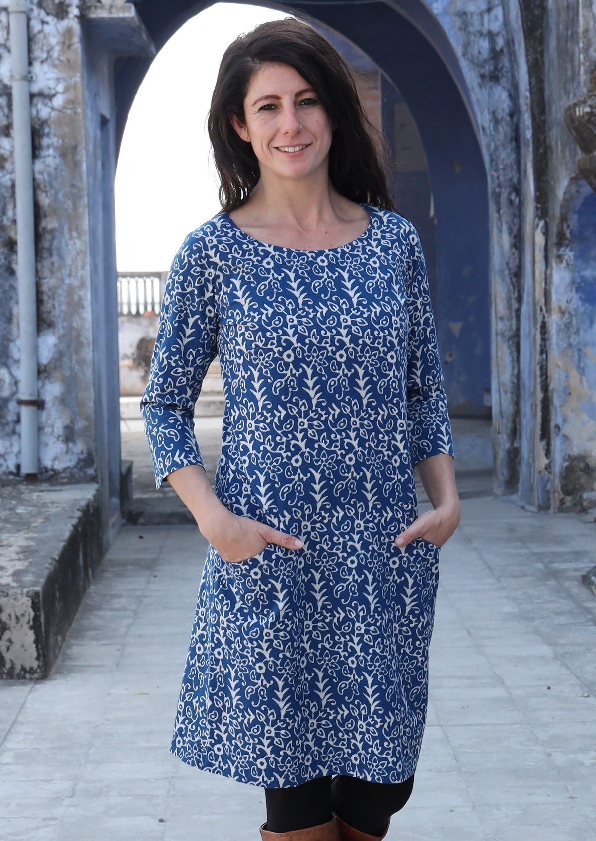 Woman standing with hands in pockets wearing 100% cotton blue and white dress 