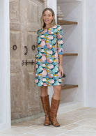 Woman wearing a colorful dress with abstract pattern and 3/4 sleeves with cuffed detailing